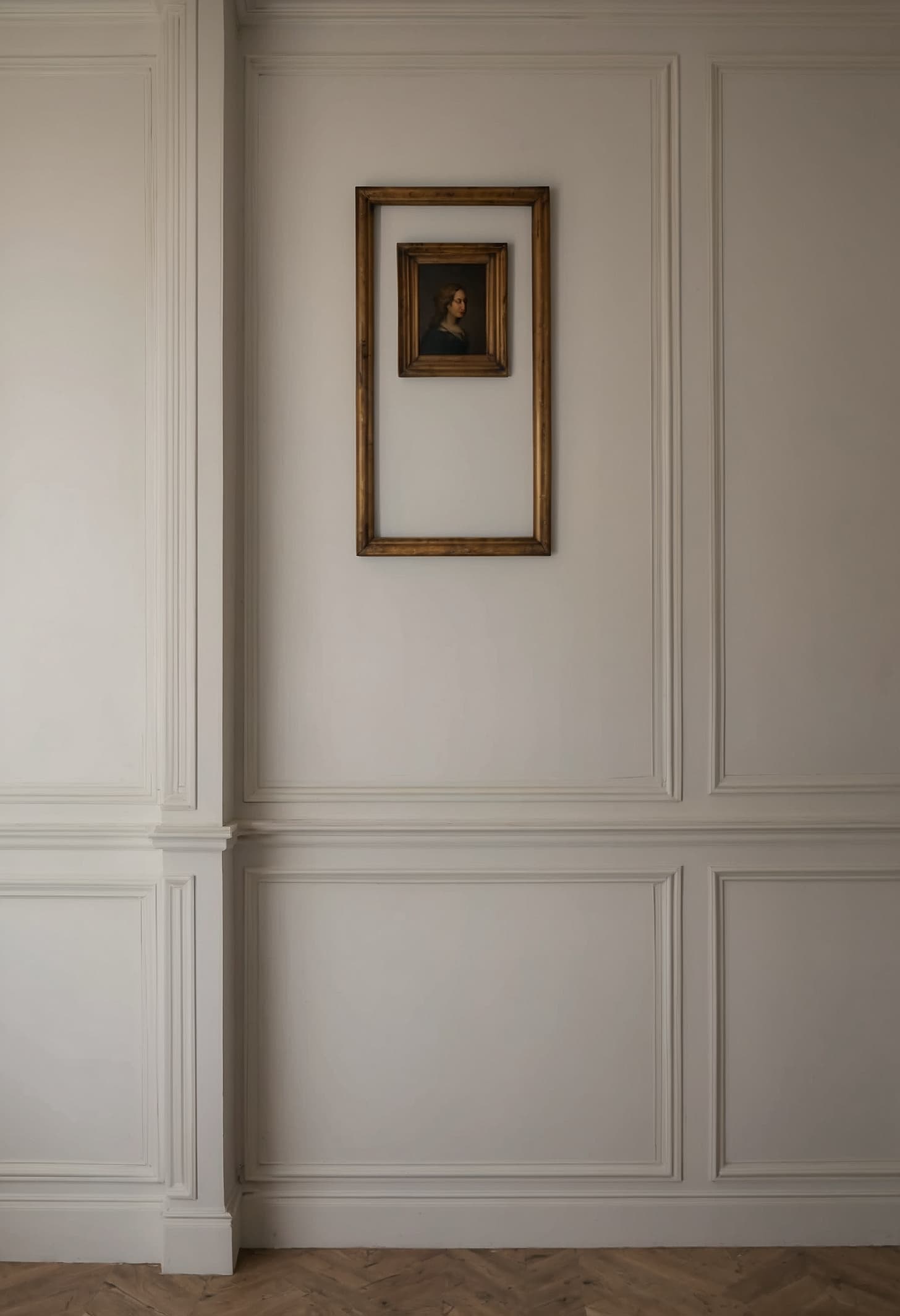 Close view of a worn brass keyhole plate set into a grey-painted wooden panel