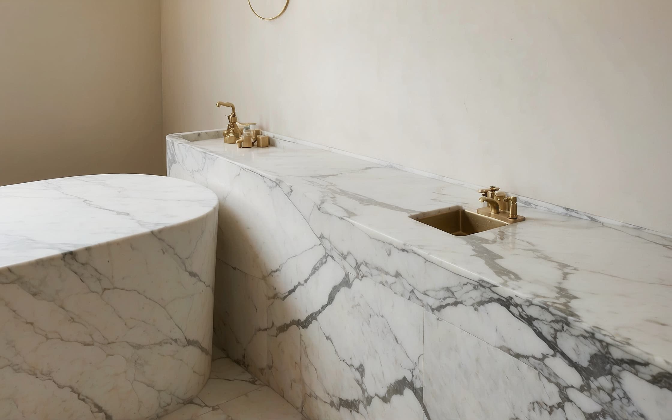 Close detail of a honed marble shelf edge meeting a brushed brass tap fitting, northern light raking across the stone.
